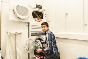 Jugendlicher am Wäsche machen - Stiftung Bühl
