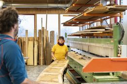 Holz wird auf Maschine gelegt - Schreinerei - Stiftung Bühl