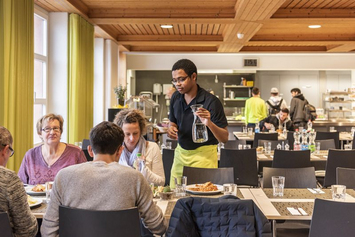 Produkte und Dienstleistungen Stiftung Bühl-Lernende der Gastronomie bedient Gäste am Tisch 
