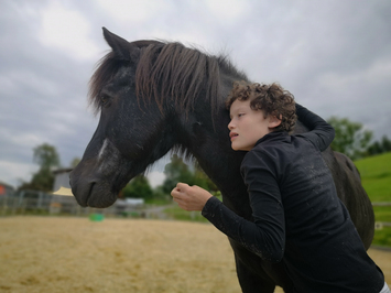 Heilpädagogische Reiten - Stiftung Bühl - schwarzes Pferd mit Kind