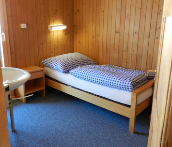 Schlafzimmer mit Einzelbett - Braunwald Ferienheim Friedheim