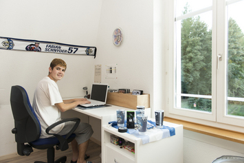 Junge sitzt am Schreibtisch - Stiftung Bühl